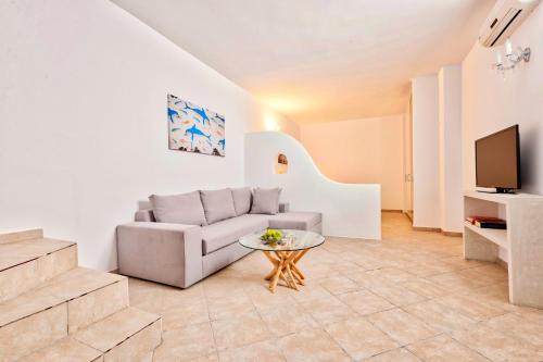 a living room with a couch and a table at Katharos Pool Villas in Oia