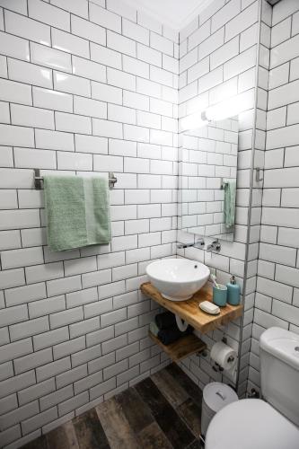 a white bathroom with a sink and a toilet at Kohili apartments in Pefkochori