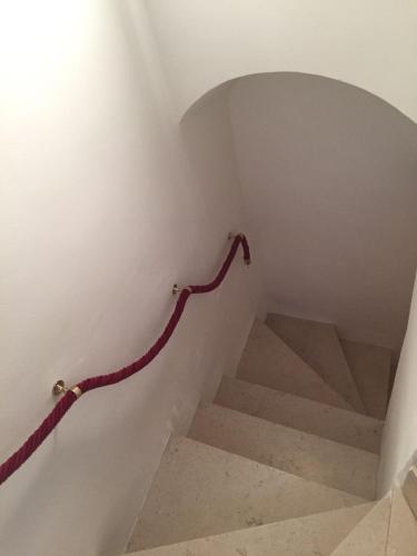 a stairway with a red rope going up a staircase at Ca' del Borgo in Venosa