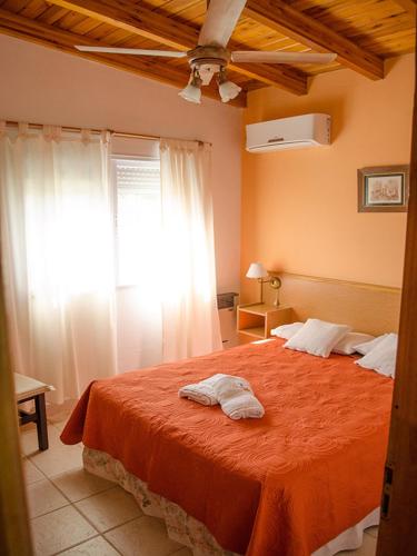 a bedroom with a bed with an orange blanket at Irundy Apartments in Federación
