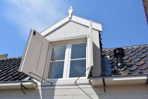 a window with a cross on top of a roof at Waterland Vakantiehuis in Monnickendam