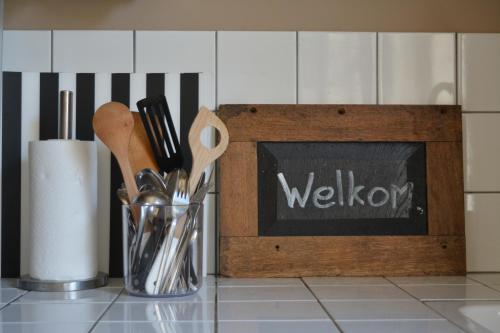 a kitchen counter with a welcome sign and utensils at Waterland Vakantiehuis in Monnickendam