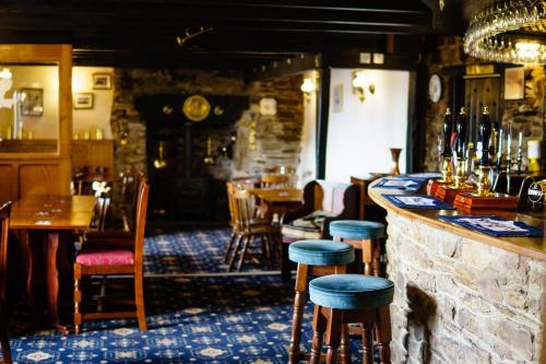 a bar in a restaurant with tables and stools at The Weary Friar Inn in Pillaton