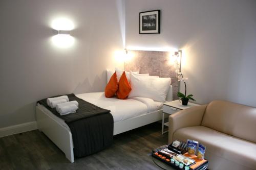a hotel room with a bed and a couch at Westciti Caroco Aparthotel in Croydon