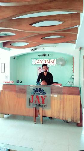 a man sitting at a desk in a law international office at Hotel Jay International in Vapi