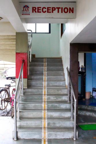 a staircase in a building with a sign on it at Hotel Jay International in Vapi