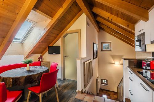 kuchnia i jadalnia ze stołem i czerwonymi krzesłami w obiekcie Taela Apartments w mieście San Cassiano