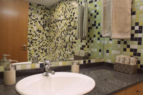 ein Badezimmer mit einem weißen Waschbecken und einer Dusche in der Unterkunft Atlantico Flat in Porto