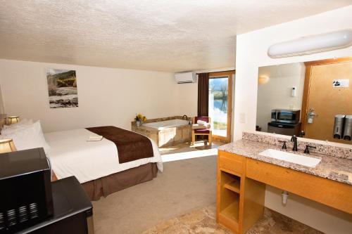 1 dormitorio con 1 cama y baño con bañera en Ninepipes Lodge en Polson