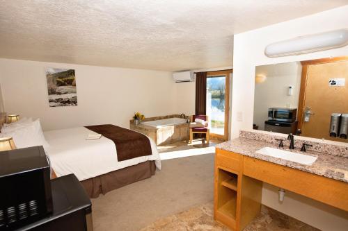 a bedroom with a bed and a bathroom with a tub at Ninepipes Lodge in Polson