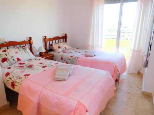 カルプにあるSunny Beach Apartmentのベッドルーム1室(ピンクと白のシーツが備わるベッド2台付)