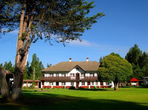 a large house sitting on top of a lush green field at Centro Vacacional Huaychulo in Concepción