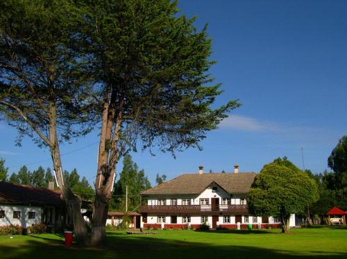a large house with a tree in front of it at Centro Vacacional Huaychulo in Concepción