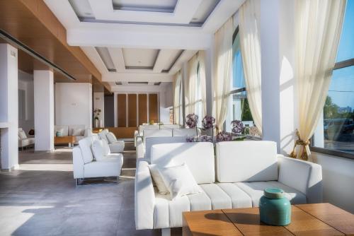 a living room with white couches and a table at Gaia in Style - Adults Only in Tigaki