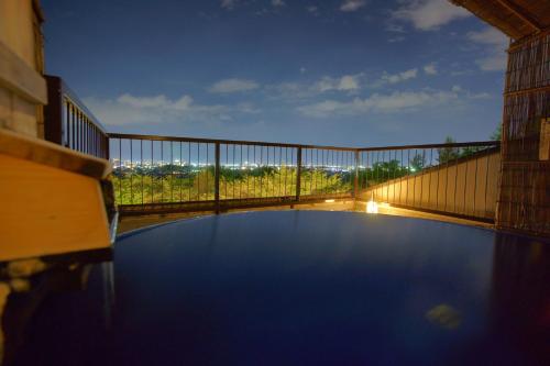 a large pool of water with a railing on a balcony at Hotel Kaminoyu Onsen in Kai