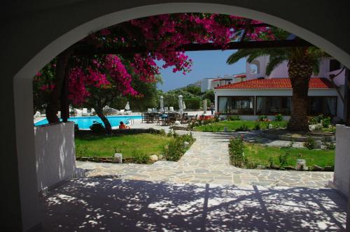un arco que conduce a una piscina y un complejo en Astron Hotel, en Karpathos