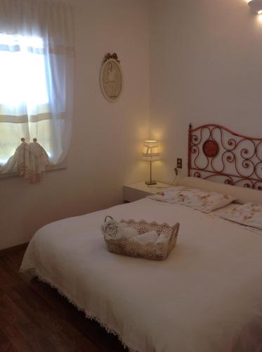 a bedroom with a white bed with a basket on it at Il Gelsomino in Iseo