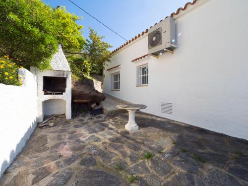 a stone patio with a bench next to a building at InmoSantos Casa Tordera in Roses