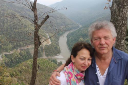 a man and a woman standing in front of a river at Mansarover Home Stay in Kalimpong