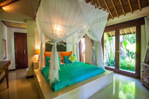 a bedroom with a bed with a canopy at Blind Dog Inn in Sanur