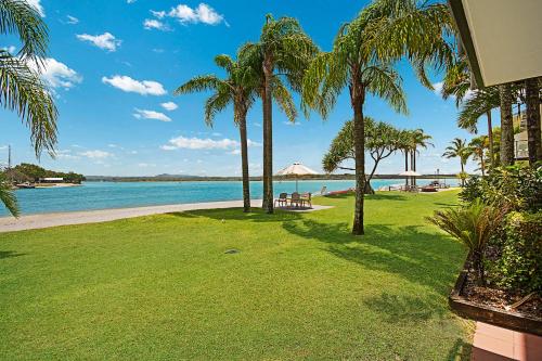 a view of the beach from a house with palm trees at Culgoa Point Beach Resort in Noosa Heads