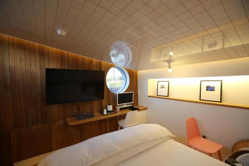a bedroom with a bed and a flat screen tv at Hotel ONDO in Daegu