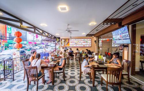 un grupo de personas sentadas en mesas en un restaurante en Mellow Space Boutique Rooms, en Karon Beach