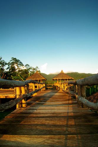 a wooden bridge with huts on top of it at The Duyan House at Sinagtala Resort in Orani