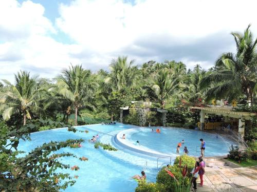 a large pool at a resort with people in it at The Duyan House at Sinagtala Resort in Orani