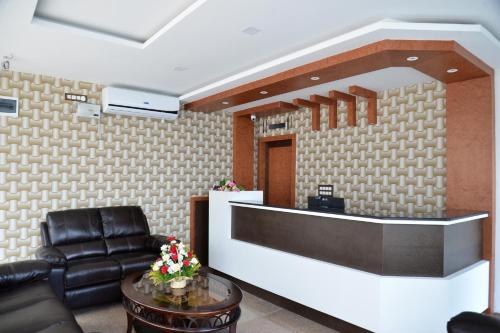 a lobby with a leather chair and a reception desk at Suroor Tourist Home in Virajpet
