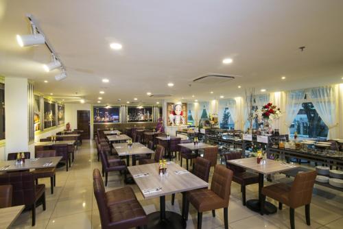 um restaurante com mesas e cadeiras e um bar em One Pacific Hotel and Serviced Apartments em George Town