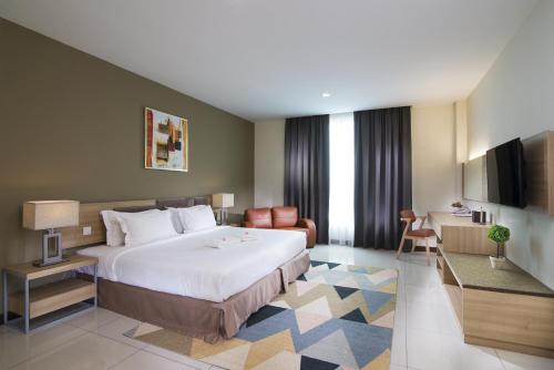 a hotel room with a bed and a living room at One Pacific Hotel and Serviced Apartments in George Town
