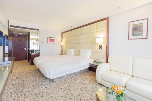 a hotel room with a bed and a couch at Regal Airport Hotel in Hong Kong