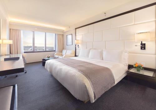 a hotel room with a large bed and a desk at Regal Airport Hotel in Hong Kong