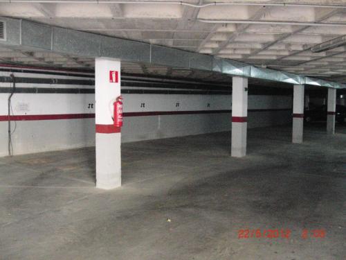 an empty parking garage with white and red columns at Apartamentos Finestrat I-II in Cala de Finestrat