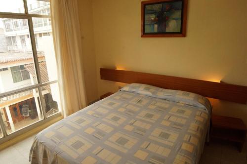 a bedroom with a bed and a large window at Grand Hotel Mercedes in Pucallpa