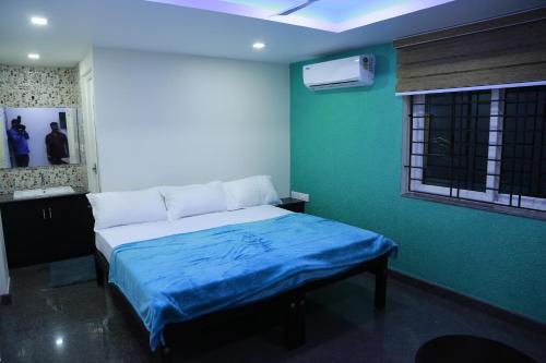 a bedroom with a bed with a blue blanket on it at Ashoka Residency Chottanikkara in Chottanikara
