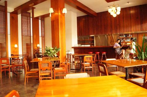 a restaurant with wooden tables and chairs and a bar at Grand Hotel Mercedes in Pucallpa