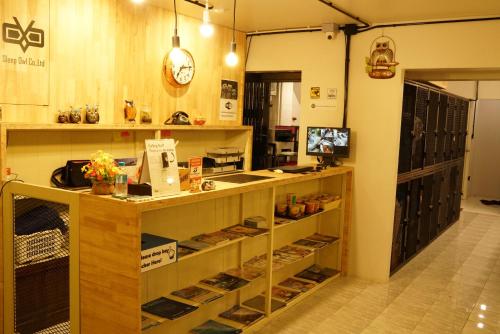 a store with a counter and shelves of items at Sleep Owl Hostel in Bangkok