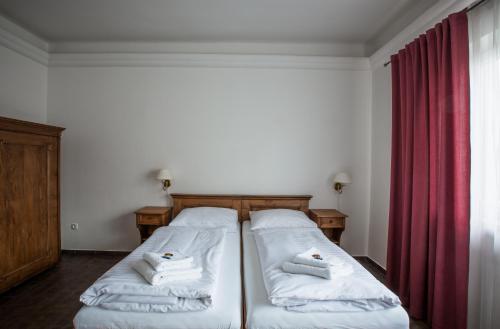 a bedroom with two beds and a red curtain at Apartmány LAGUNA in Kopřivnice
