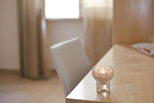a candle in a glass sitting on a table at Donna Rosa Accommodation in Tropea