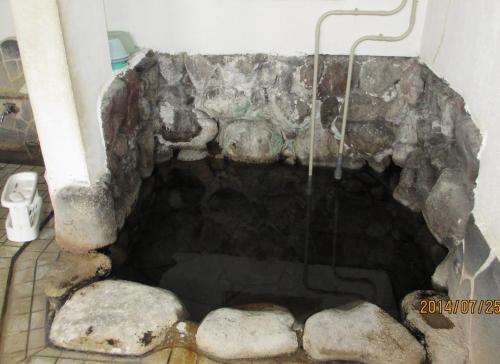 a cave in a bathroom with rocks in it at YOKOSO Ryokan in Beppu