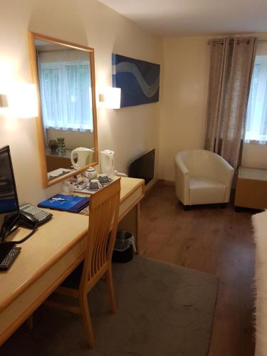 a room with a desk with a computer and a mirror at Travel Plaza Hotel in Desborough