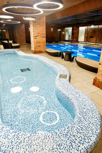 a large swimming pool in a large building with a pool at Grand Walkerhill Seoul in Seoul