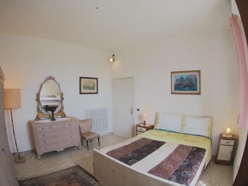 a bedroom with a bed and a dresser and a mirror at Casa DUILIA in Castellina in Chianti