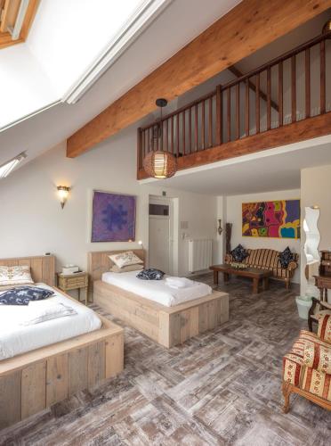 a bedroom with two beds and a staircase at B&B AntiQua & Qook in Tongeren