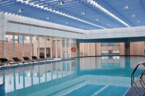 a large swimming pool with chairs in a building at Huangyan Yaoda Hotel in Taizhou