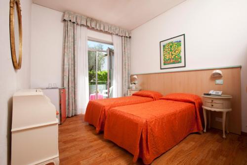 1 dormitorio con 2 camas y ventana en Hotel Residence Rely, en Brenzone sul Garda