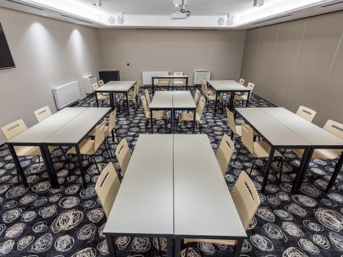 an empty classroom with tables and chairs in it at Hotel Center Novo Mesto in Novo Mesto