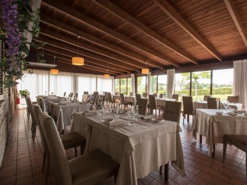 a banquet hall with tables and chairs with white tablecloths at Osteria dei Segreti in Appignano